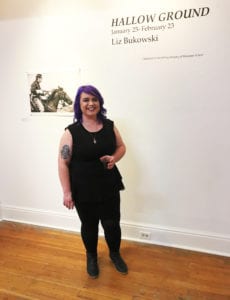 Liz Bukowski stands with calvary soldier #1, an archival inkjet print, at the opening of Hallow Ground.