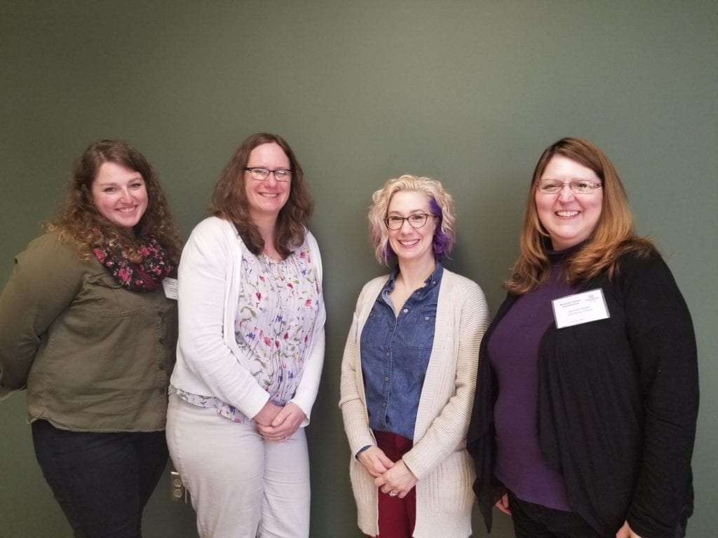 Four professional women smiling